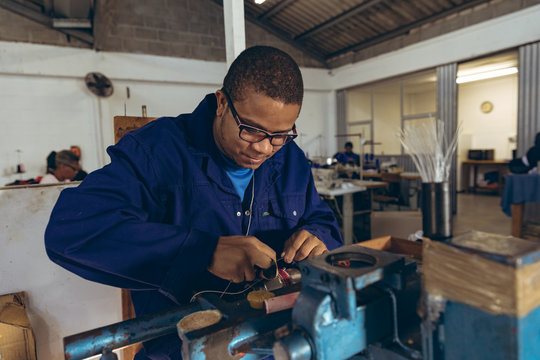 Young man working in a sports equipment factory