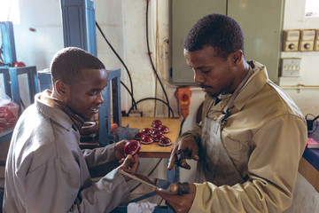 Young men working using tablet in a sports equipment factory