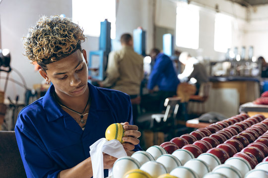 Young man working in sports equipment factory