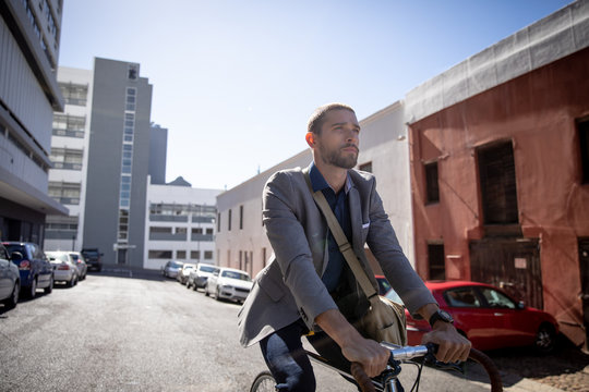 Young professional man riding a bike in a city