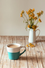 Close up of a cup of morning coffee and a bouquet of yellow flowers on a background