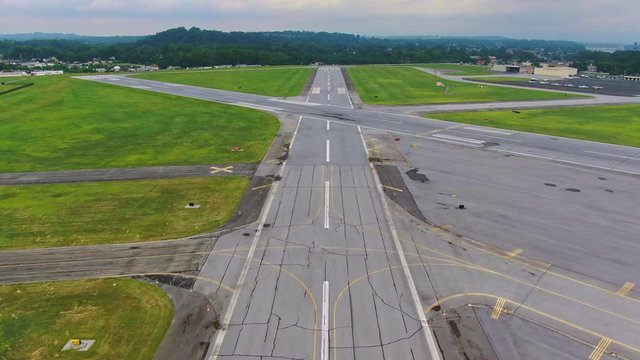 High speed low pass above runway, pilots perspective, aerial view of airport with intersecting runways, Navy F-14 Tomcat parked to the left of runway