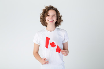Happy young woman with the flag of Canada on a light background. Portraits female Canadian,...
