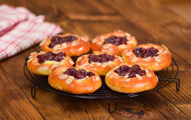 Sweet homemade buns with cherry berries on rustic background.