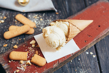 studio shot of tasty ice cream in cone on wooden table