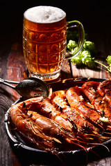 Beer and langoustines on a dark background.
