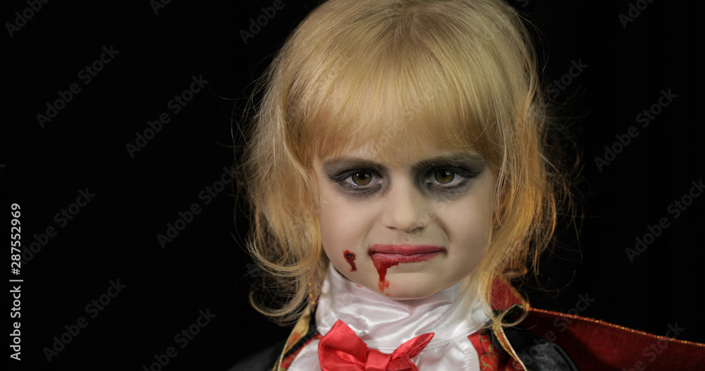 Wall mural Dracula child. Girl with halloween make-up. Vampire kid with blood on her face - Wall murals