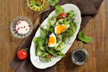Cucumber, tomato, egg, fresh green salad with black sesame, top view