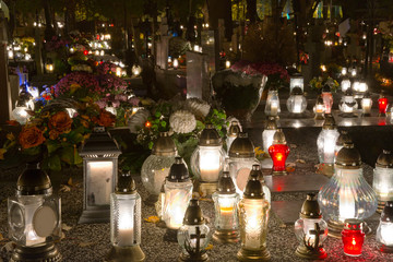 Candles and chrysanthemums at night in the cemetery