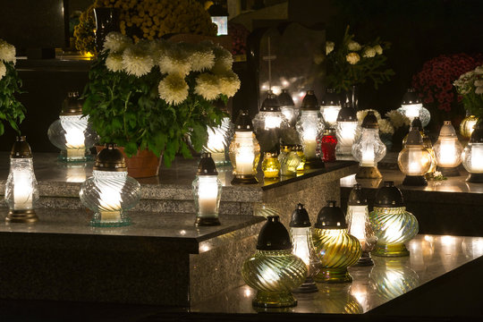 Candles and chrysanthemums at night in the cemetery