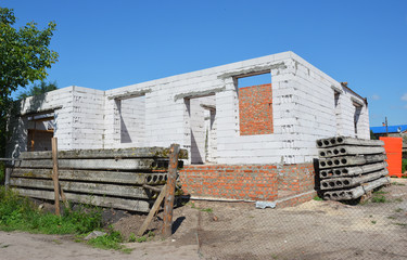 House under construction with no roof, brick foundation and aerated concrete blocks