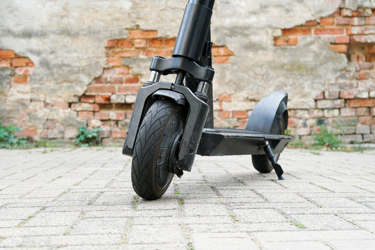 Electric kick scooter or e-scooter parked on pavement - e-mobility or micro-mobility trend