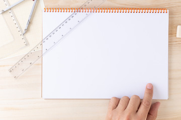 Obraz premium left male hand pointing to an empty page of a spiral bound notebook