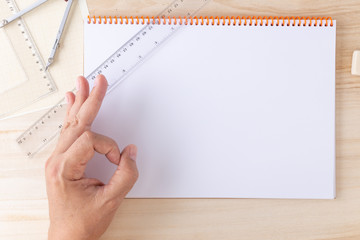 male hand indicating either agreement or readiness over a technical draftsman desk