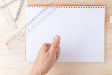 male hand indicating agreement or readiness over a technical draftsman desk