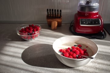 Closeup of oat flakes with berry fruit on the desk in the kitchen