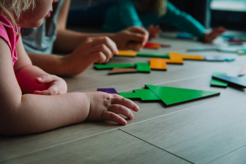Obraz na płótnie Canvas teacher and kids play with puzzle, doing tangram