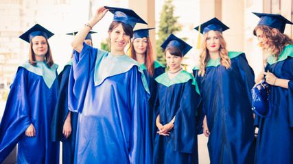 A group of young female graduates. Female graduate is smiling against the background of university graduates.