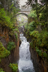 Fototapeta na wymiar Pont d’Espagne, stone-built arch bridge over wild river in ravine in the French Pyrenees