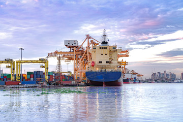 Cargo freight ship and cargo container working with crane at port area,Logistic Import Export at sunset,Thailand 4.0