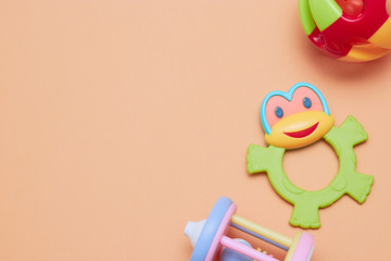 top view of children's educational toys. Bright plastic, a plastic set of toys for children. Flatlay with space for text on a peach background.