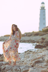 Beautiful woman on the nature. Woman by the sea at sunset.