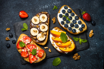 Obraz na płótnie Canvas Sweet toast assortment with fresh fruit and berries on black.