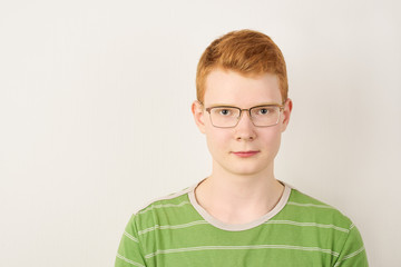 Redhead young man with glasses on white background