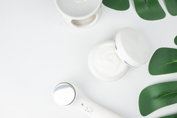 flat lays Cosmetic bottle containers cream , serum, skincare Blank bottle label package for branding with herb and green leaves on white background.Cosmetic Natural organic beauty product concept.