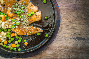 pork chops  in a hot pan, put on an old wooden table.