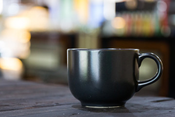 Black Coffee mug on wooden table in coffee shop