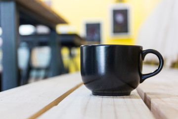 Black Coffee mug on wooden table in coffee shop
