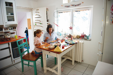 Mother and daughter painting Christmass ornaments	