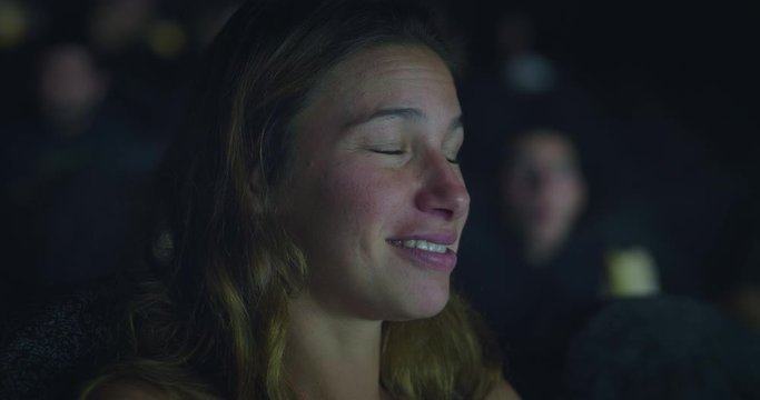Authentic shot of an young woman is excited to enjoy a movie in cinema.