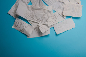 Pile of shopping receipts on blue background