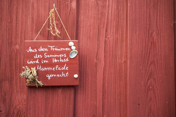 Schild an roter Holzwand