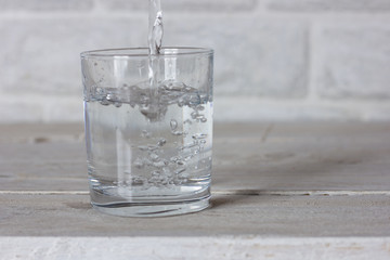 Dishes. Glass cup with water on a white wooden table