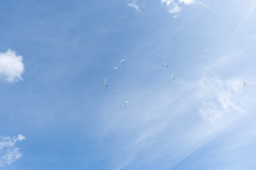 Circle of Paragliders in a sky with one outside
