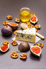 Cheese appetizer selection or wine snack set. Blue cheese, figs, honey, walnuts, pretzels