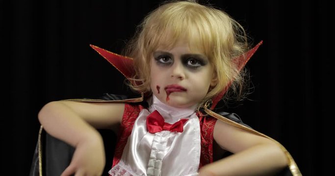 Dracula child. Girl with halloween make-up. Vampire kid with blood on her face