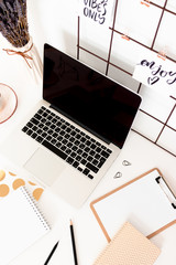 Workspace with mood board, laptop, stationery and flowers