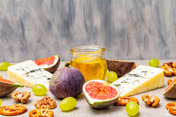 Cheese appetizer selection or wine snack set. Blue cheese, figs, honey, walnuts, pretzels