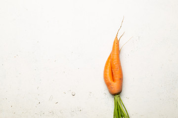 Ugly carrots on a white background. Ugly food concept, top view.