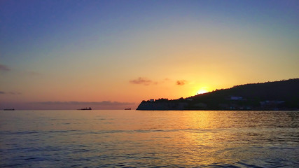 Naklejka na ściany i meble Sunset at sea, ships far into the sea.
