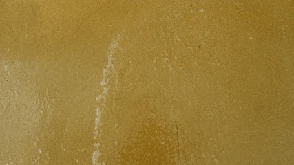 Emoji. Top view of the wave washing away the sad face drawn on the sand of sandy beach of Mediterranean sea. 4K