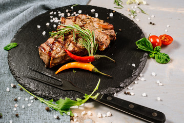Tasty roasted steak with spices on the wooden background