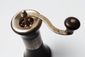 Ancient pepper mill on white background.
