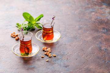 Traditional Turkish arabic dessert and a glass of tea with mint