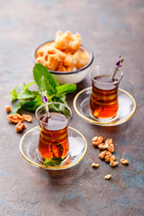 Traditional Turkish arabic dessert and a glass of tea with mint