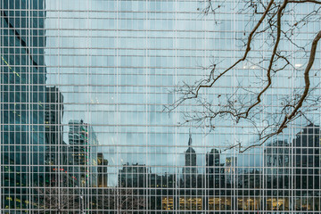 New York City, NY, USA - December, 2018 - Streets of Manhattan, Skyline view reflected like a mirror in a building in front of Bryant Park.